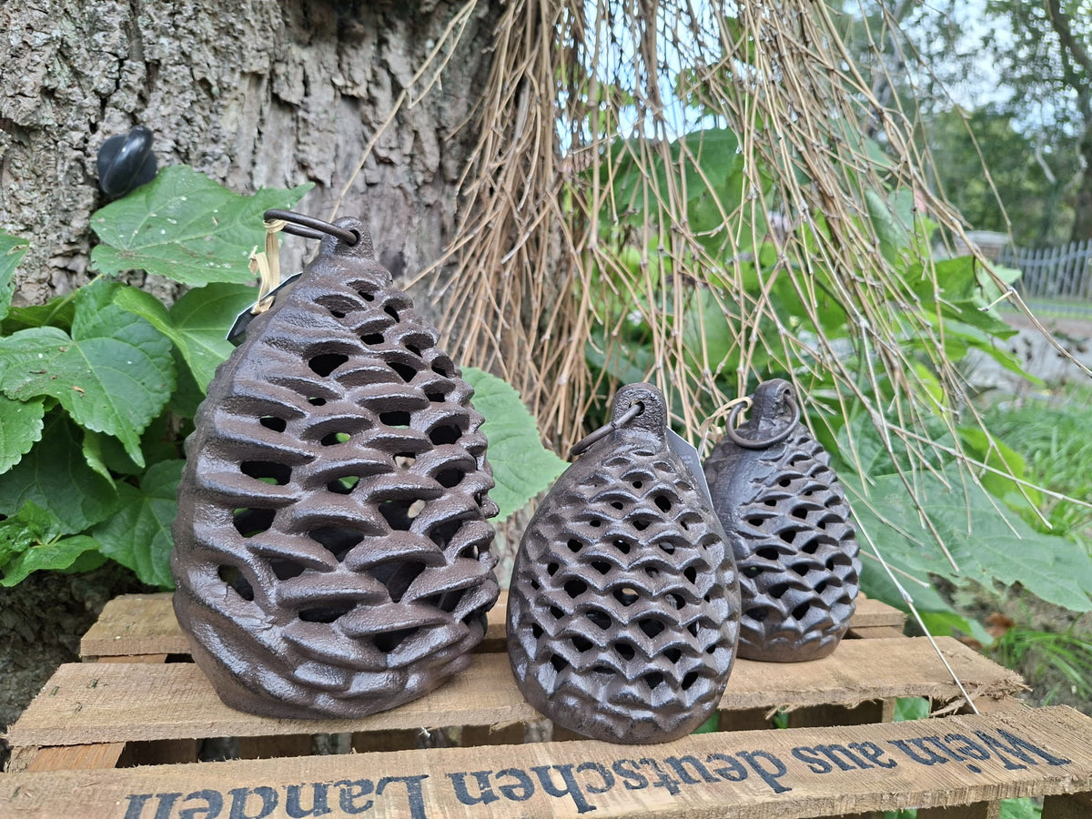 Gusseiserne Teelichtlaterne in Tannenzapfenform mit dekorativem Licht- und Schattenspiel